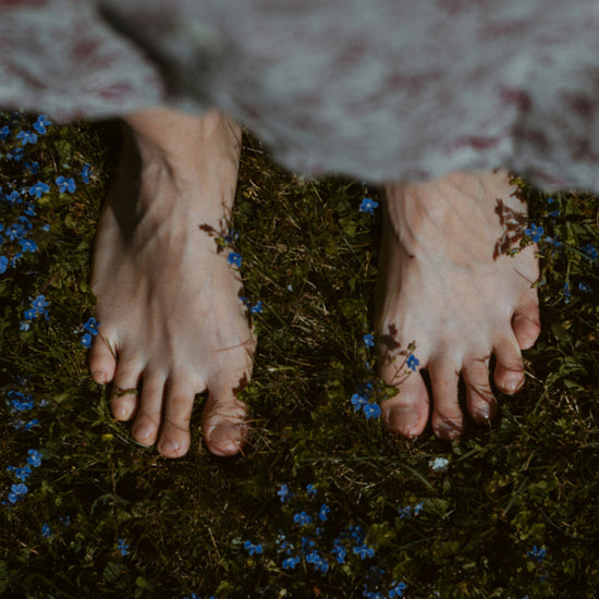 Womans feet on grass and flowers